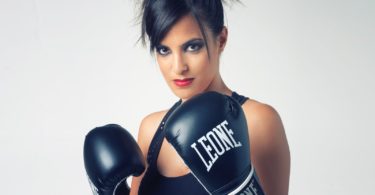 woman wearing black Leone leather boxing gloves