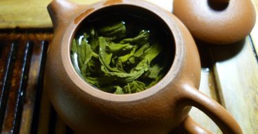 green leaves and clear liquid inside teapot