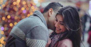 shallow photography of man hugging woman outdoors