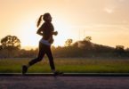 woman in black sports bra and black pants running on water during sunset