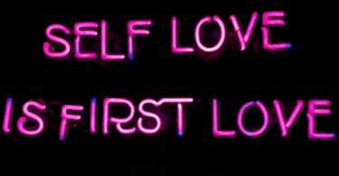 a neon sign that says self love is first love